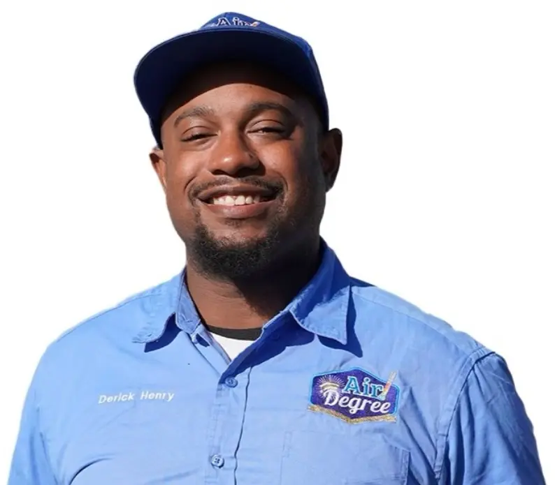 A man in blue shirt and hat smiling for the camera.