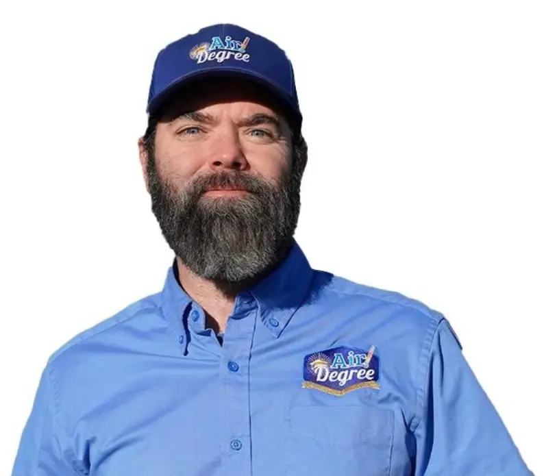 A bearded man wearing a blue shirt and hat.