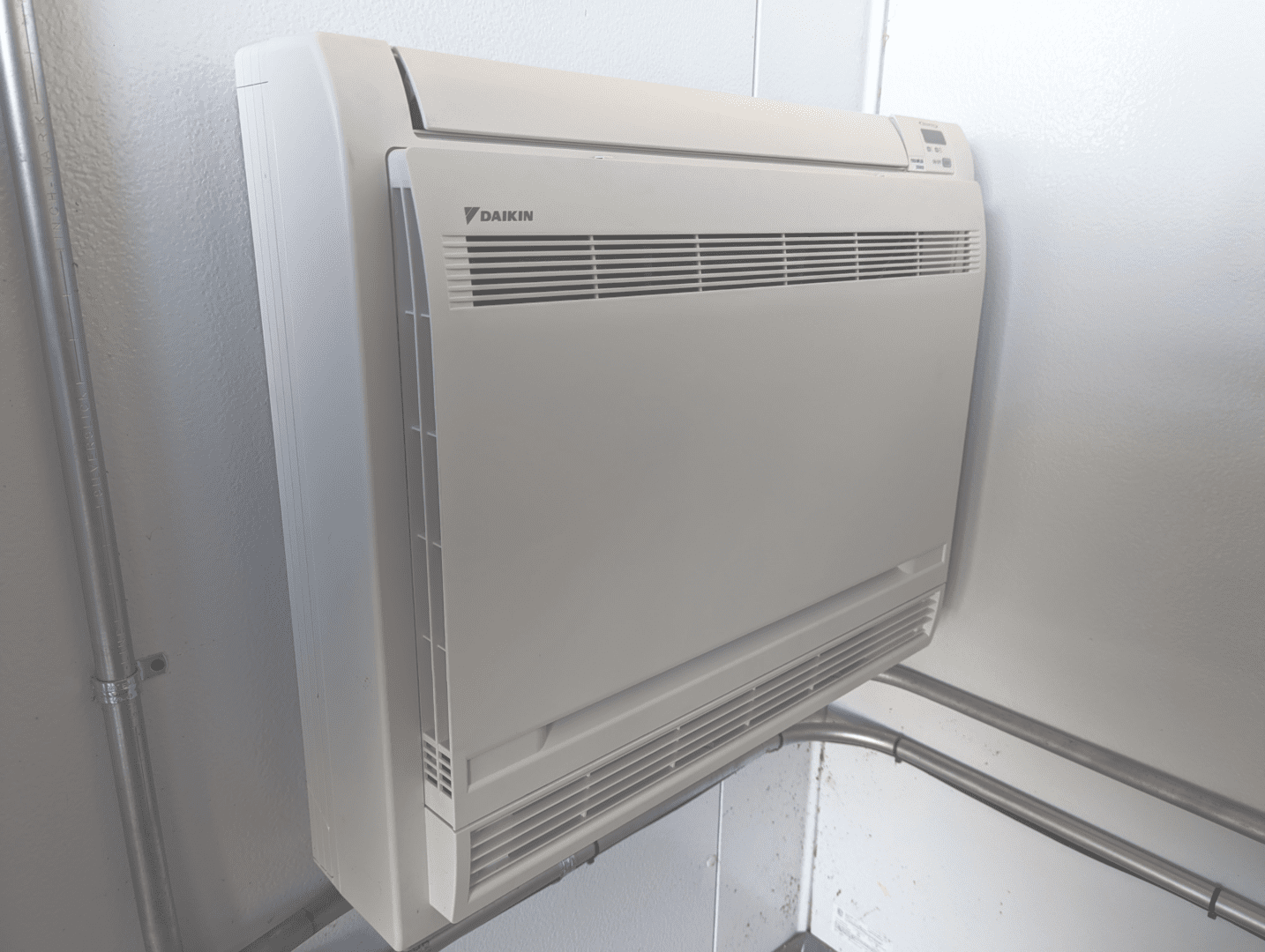 A white air conditioner mounted to the side of a wall.